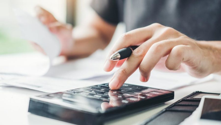 a photo of someone using a calculator to start investing in CDs.