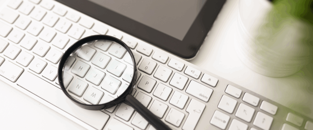 Magnifying glass on computer keyboard symbolizing FHA loan research tools