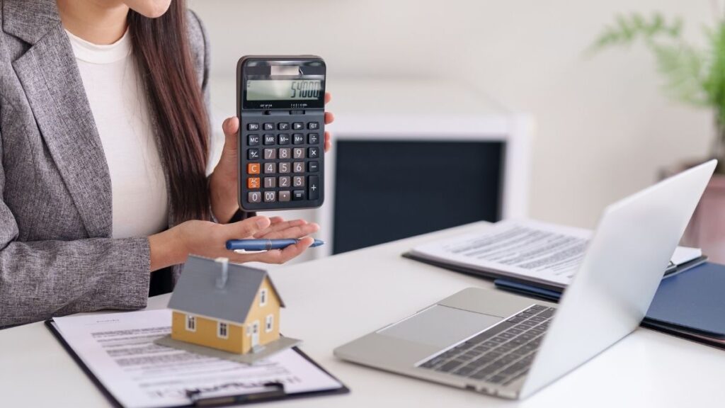 A woman holding a calculator while working on FHA Loans