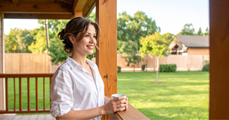 Utah resident standing on the front porch of her first home