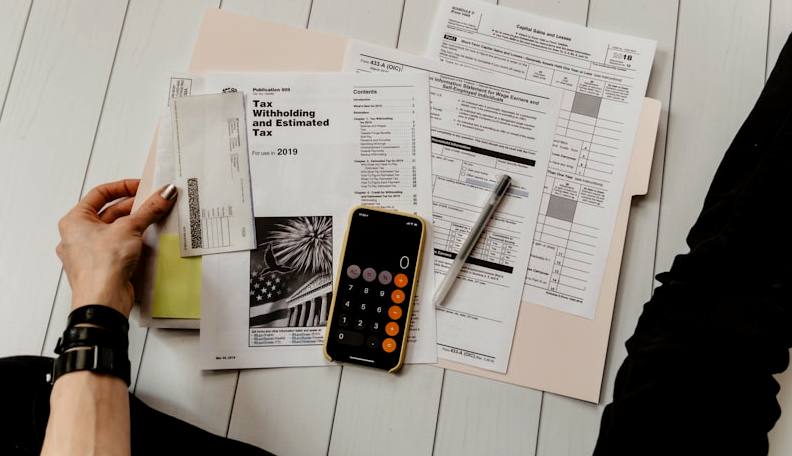 Tax documents, calculator, and paperwork used to gather financial records for a first time home buyer pre approval application in Utah